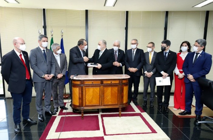 Entre senadores da CPI, o presidente da comissão, Omar Aziz (E), entrega ao procurador Augusto Aras o relatório final do colegiado em 27 de outubro