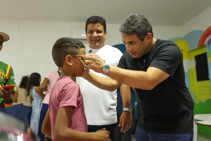 Deputado Osmar Filho entrega óculos a criança durante ação do programa Cuidar dos Olhos em São José de Ribamar