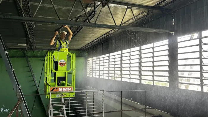 Trabalhador limpa a cobertura de uma construção no IE Doutor Carlos Chagas, em Canoas, com um jato d'água -Foto: Laiz Flores/Ascom SPGG