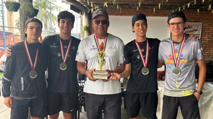 Equipe de tênis masculino com medalhas e troféu