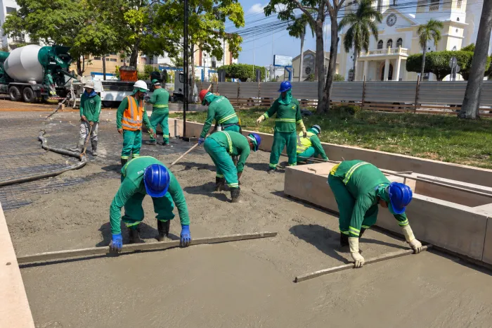 Equipes trabalham na concretagem das calçadas e na instalação das madeiras que vão compor os bancos da praça