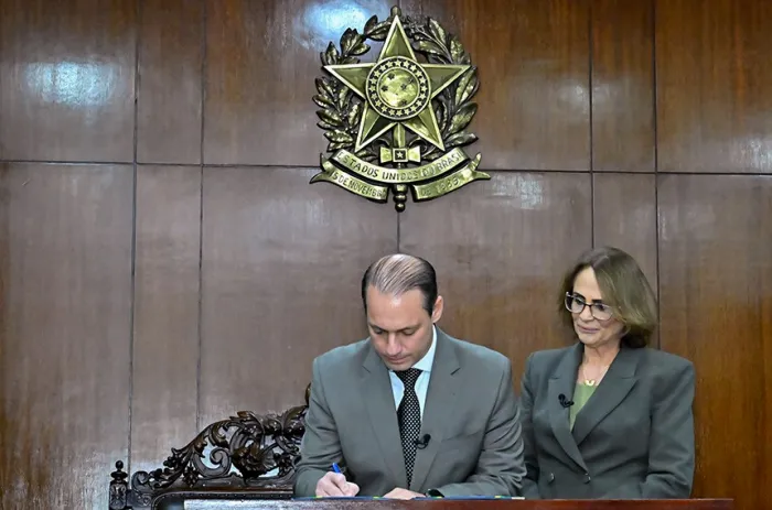 Renzo Braz assina o termo de posse, ao lado de Damares Alves - Foto: Waldemir Barreto/Agência Senado
